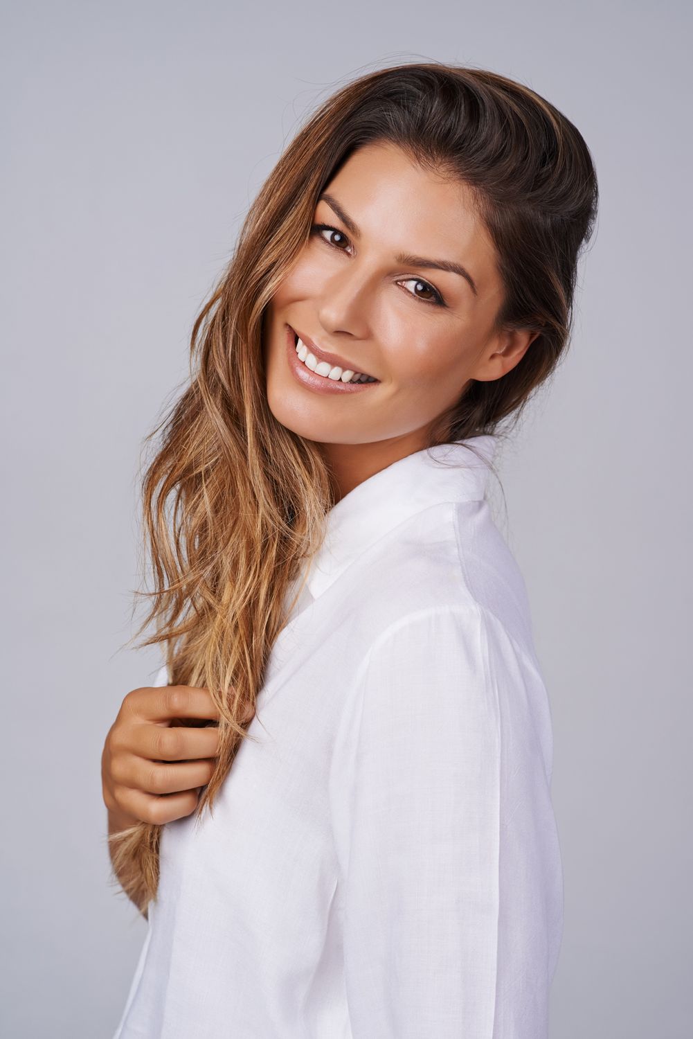 Smiling woman with long hair in white shirt.